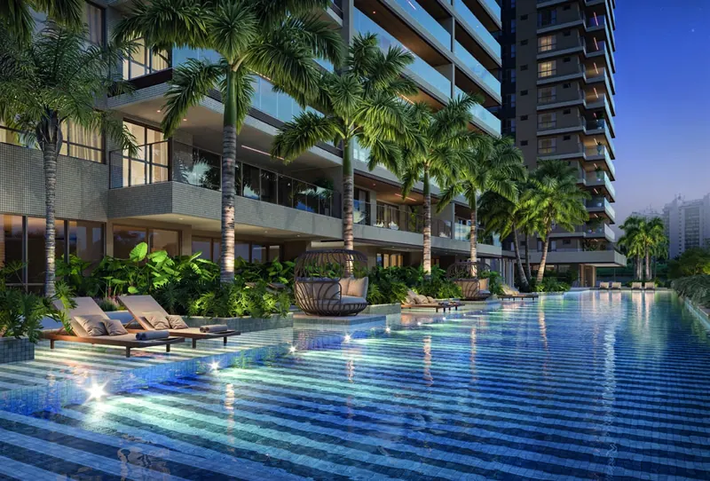 Piscina iluminada à noite entre os edifícios do Gran Thai Leisure Residence